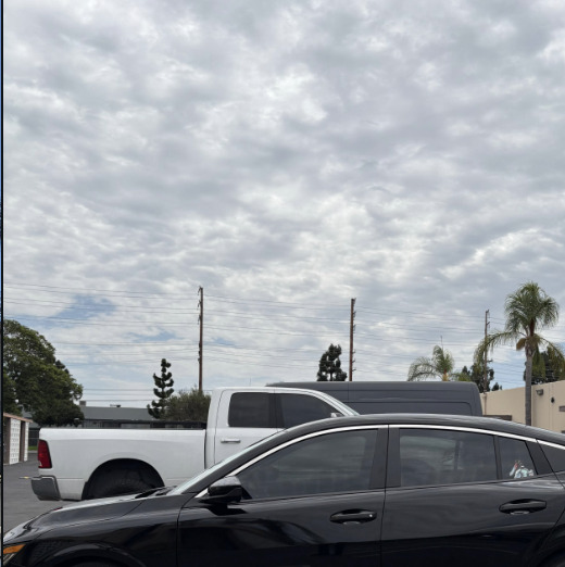 A dark SUV and a white truck parked in the shop lot